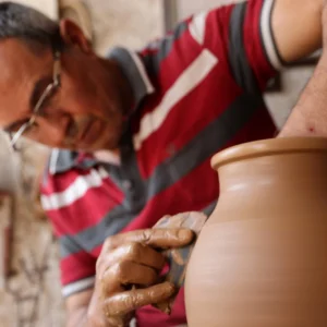 Artisan carving intricate patterns into pottery in Avanos