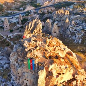 Tourists climbing Uchisar Castle for panoramic views of Cappadocia