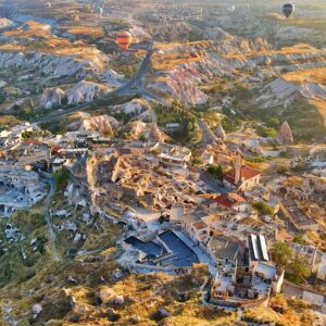 Hot air balloons flying over Uchisar Castle at sunrise