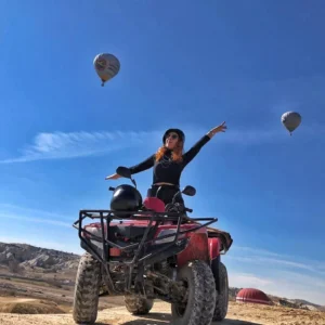 ATV riders exploring Cappadocia’s valleys at sunset with fairy chimneys in the background